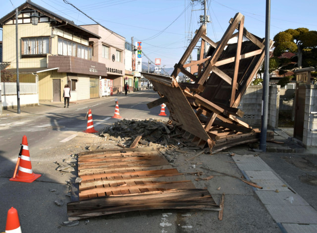 Pagar rumah yang rusak akibat gempa di kota Kori, utara kota Fukushima, timur laut Jepang, Minggu (14/2). Foto: Kyodo News via AP