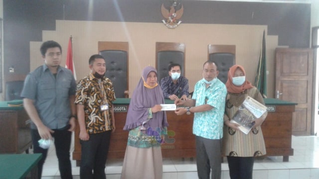 Darsulin, warga Desa Sumurgeneng, Kecamatan Jenu, Kabupaten Tuban, saat terima cek ganti rugi pembebasan lahan proyek Kilang Minyak NGRR dari Pengadilan Negeri Tuban. Rabu (17/02/2021) (foto: ayu/beritabojonegoro)