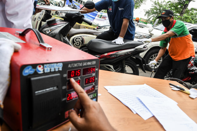 Petugas melakukan uji emisi gas buang kendaraan bermotor di Jalan Pemuda, Jakarta Timur. Foto: M Risyal Hidayat/ANTARA FOTO