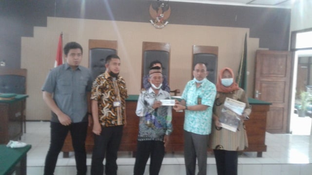 Matraji, warga Desa Sumurgeneng, Kecamatan Jenu, Kabupaten Tuban, saat terima cek ganti rugi pembebasan lahan proyek Kilang Minyak NGRR dari Pengadilan Negeri Tuban. Rabu (17/02/2021) (foto: ayu/beritabojonegoro)