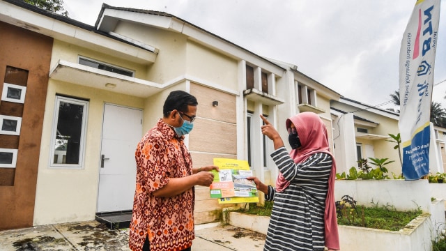 Petugas pemasaran perumahan menyerahkan dokumen Kredit Pemilikan Rumah (KPR) kepada pembeli di Perumahan Taman Harapan, Tajur Halang, Bogor, Jawa Barat, Rabu (17/2/2021). Foto: Muhammad Adimaja/ANTARA FOTO