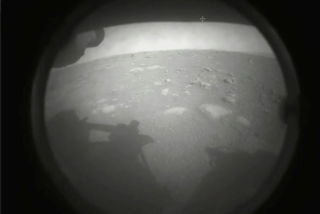 Gambar pertama yang dikirim oleh robot penjelajah Perseverance yang menunjukkan permukaan Mars, tepat setelah mendarat di kawah Jezero, Kamis (18/2). Foto: NASA via AP