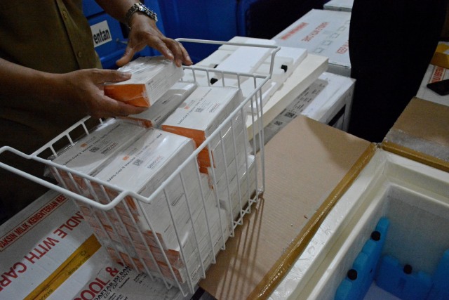 Petugas menata kemasan vaksin COVID-19 Sinovac sebelum dimasukan ke dalam lemari pendingin khusus vaksin di Instalasi Farmasi Dinas Kesehatan Kabupaten Garut, Jawa Barat. Foto: Candra Yanuarsyah/Antara Foto