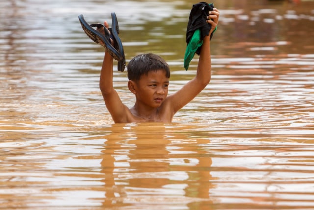 Seorang anak kecil berenang melintasi banjir di Desa Dawuan Tengah, Cikampek, Karawang, Jawa Barat, Jumat (19/2).  Foto: M Ibnu Chazar/ANTARA FOTO