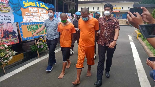 Tersangka NP dan RB digelandang petugas usai rilis Kapolres Malang.(foto:Rizal Adhi Pratama).