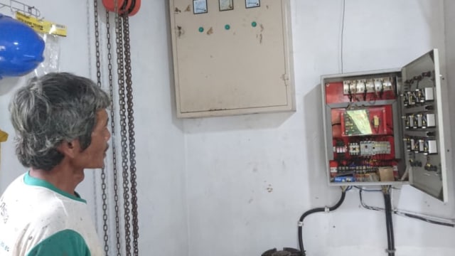 Rejo Handoyo menunjukkan sikring pengatur aliran listrik mikro hidro. Foto: Widi Erha Pradana. 