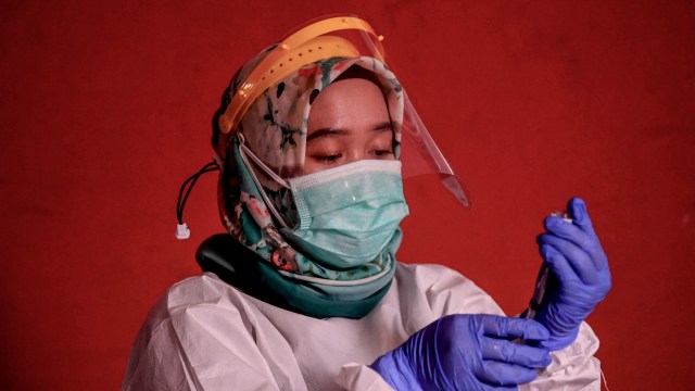 Petugas kesehatan bersiap menyuntikan vaksin COVID-19 kepada pedagang di Blok A Pasar Tanah Abang Jakarta, Kamis (25/2/2021).  Foto: WAHYU PUTRO A/ANTARA FOTO