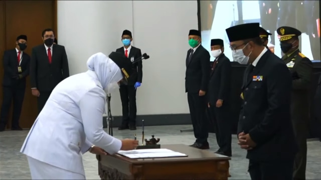 Bupati Karawang dr. Hj. Cellica Nurrachadiana  saat menandatangani berita acara pelantikan