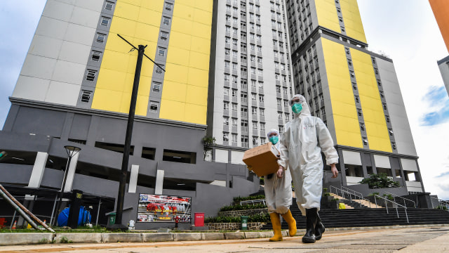 Petugas kesehatan Rumah Sakit COVID-19 Wisma Atlet berjalan membawa kotak obat pasien di Jakarta, Jumat (26/2/2021). Foto: Muhammad Adimaja/ANTARA FOTO