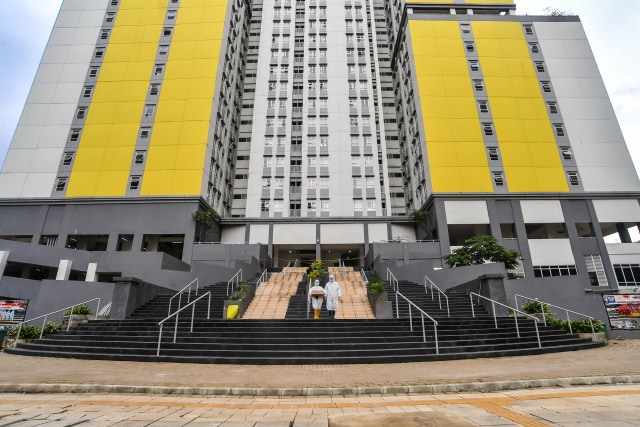 Petugas kesehatan Rumah Sakit COVID-19 Wisma Atlet berjalan membawa kotak obat pasien di Jakarta, Jumat (26/2/2021). Foto: Muhammad Adimaja/ANTARA FOTO