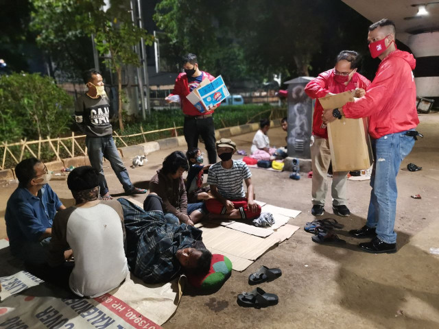 Kader-kader Partai Solidaritas Indonesia membagikan makanan siap saji pada warga yang terpaksa menggelandang di Kawasan Kampung Melayu, Jakarta Timur, akibat PSBB ketat di awal Mei 2020. PSI memindahkan beberapa keluarga yang memiliki anak-anak di bawah umur, ibu hamil, dan penderita penyakit kronis ke rumah kontrakan atau rumah kos.