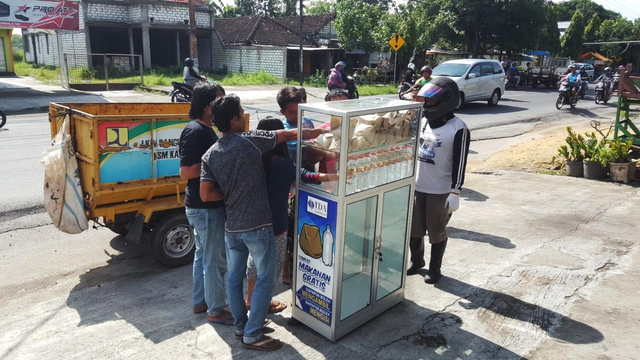 Warga mengantri mengambil nasi bungkus dan sebotol air mineral yang disiapkan TDA Lamongan. (dok/TDA Lamongan).