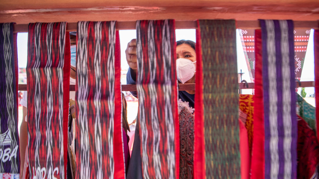 Pengunjung memilih kain ulos yang dipamerkan dilokasi peluncuran Gerakan Nasional (Gernas) Bangga Buatan Indonesia (BBI) Beli Kreatif Danau Toba di Paropo, Dairi, Sumatera Utara. Foto: Nova Wahyudi/ANTARA FOTO