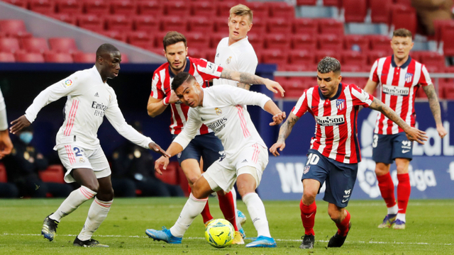 Pemain Real Madrid Casemiro berebut bola dengan pemain Atletico Madrid pada pertandingan lanjutan Liga Spanyol di Wanda Metropolitano, Madrid, Spanyol. Foto: Susana Vera/REUTERS