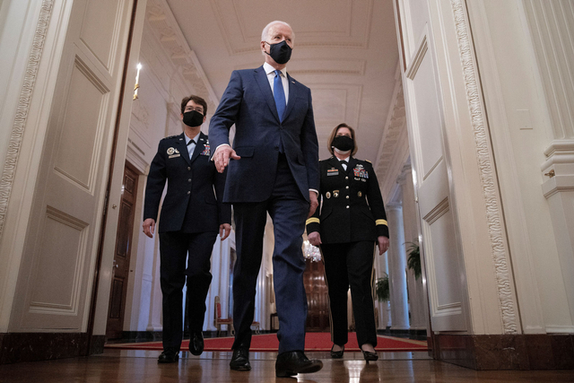 Presiden AS Joe Biden berjalan ke Ruang Timur di samping Jenderal Angkatan Udara AS Jacqueline Van Ovost dan Letnan Jenderal Angkatan Darat AS Laura J. Richardson sebelum menyampaikan sambutan pada Hari Perempuan Internasional di Gedung Putih (8/3). Foto: Tom Brenner/REUTERS