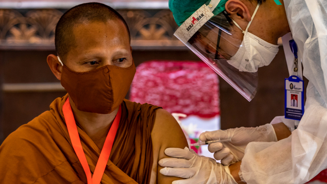 Vaksinator menyuntikkan vaksin COVID-19 Sinovac kepada seorang Bhante (Rohaniawan Agama Buddha) di Masjid Agung Jawa Tengah, Semarang, Rabu (10/3/2021). Foto: Aji Styawan/ANTARA FOTO