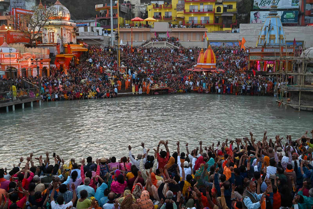 Umat Hindu menghadiri ritual petang setelah berendam di air Sungai Gangga pada kesempatan festival Maha Shivratri selama festival keagamaan Kumbh Mela di Haridwar (11/3/2021). Foto: PRAKASH SINGH/AFP