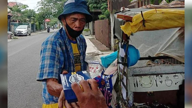 Seorang penarik becak menerima nasi kotak dari TDA Bandung.(dok/TDA Bandung).