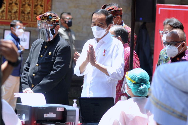 Presiden Joko Widodo (tengah) berbincang dengan tenaga kesehatan saat meninjau proses vaksinasi COVID-19 di Puri Ubud, Gianyar, Bali, Selasa (16/3).  Foto: Fikri Yusuf/ANTARA FOTO