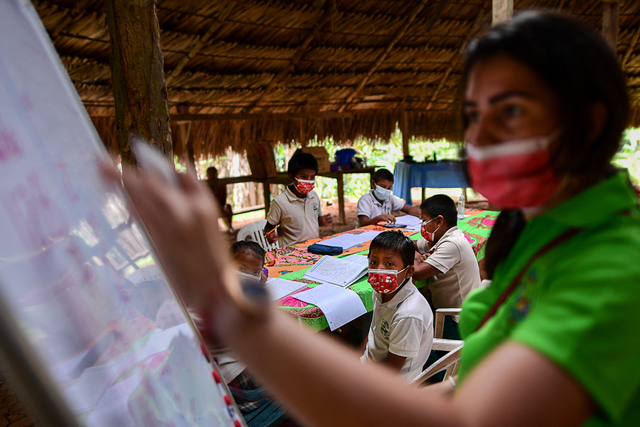 Guru Panama Graciela Bouche (kanan) memberikan pelajaran kepada anak-anak adat Embera di komunitas Ella Puru Embera, provinsi Colon, Panama, pada 09 Maret 2021. Foto: LUIS ACOSTA/AFP