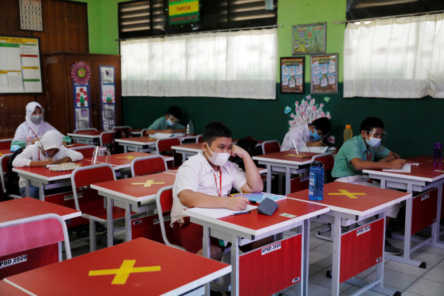 Sejumlah siswa mengenakan masker dan menrapkan jaga jarak soial (social distancing) mengikuti kegiatan belajar tatap muka di Bekasi, Rabu (24/3).  Foto: Willy Kurniawan/REUTERS
