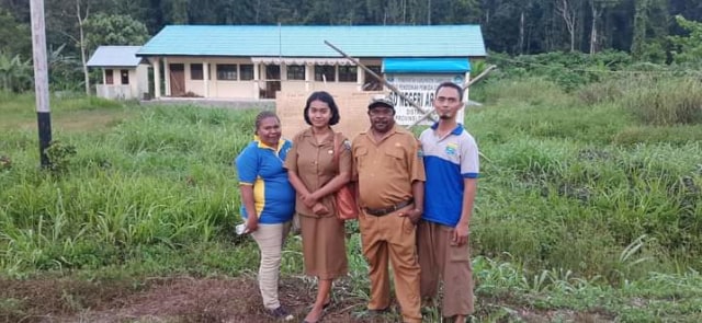 Kepala Bidang Pendidikan SD pose bersama stafnya di depan SDN Araouw saat sebelum dibuka pemalangannya