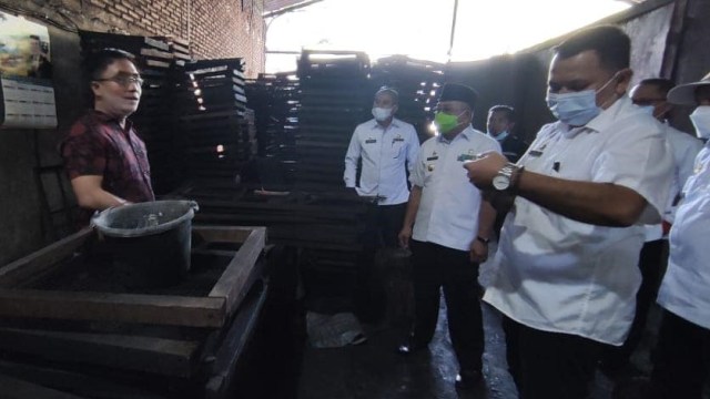 Gubernur Sulbar, Ali Baal Masdar, saat mengunjungi pabrik briket tempurung kelapa milik Sudirman Abu. Foto: Dok. Kominfo Sulbar