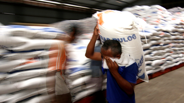 Pekerja mengangkut beras di Gudang Bulog Ketapang II, Banyuwangi, Jawa Timur. Foto: Budi Candra Setya/ANTARA FOTO