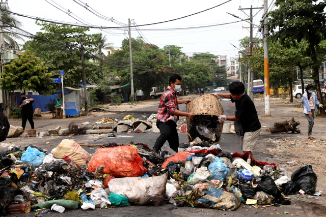 Warga membuang sampah untuk memblokir jalan sebagai bentuk protes di kotapraja Thaketa, Yangon, Myanmar. Foto: Stringer/Reuters