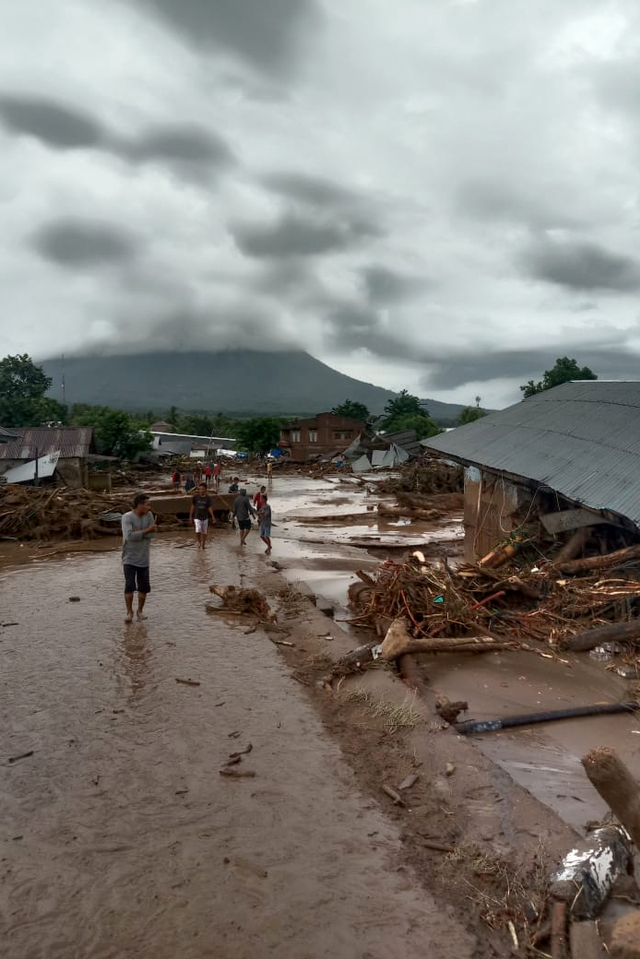 Sejumlah warga menyaksikan rumah yang rusak akibat banjir bandang di Desa Waiburak, Kecamatan Adonara Timur, Flores Timur, NTT, Minggu (4/4). Foto: BPBD Flores Timur/HO/ANTARA FOTO