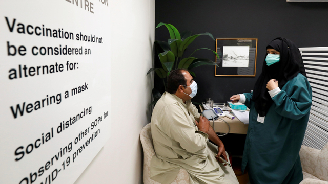 Seorang penduduk menerima dosis komersial vaksin corona Sputnik V asal Rusia, di sebuah rumah sakit swasta di Karachi, Pakistan. Foto: Akhtar Soomro/Reuters