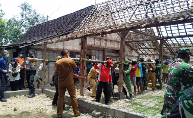 Pembangunan rumah secara gotong royong yang menjadi salah satu kegiatan pengabdian prajurit TNI kepada masyarakat. Foto-foto: Pendam V Brawijaya