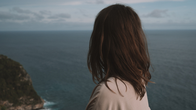 Ilustrasi perempuan menatap laut yang membuatnya berpisah dengan teman-temannya. Foto: Unsplash/Polina Kuzovkova