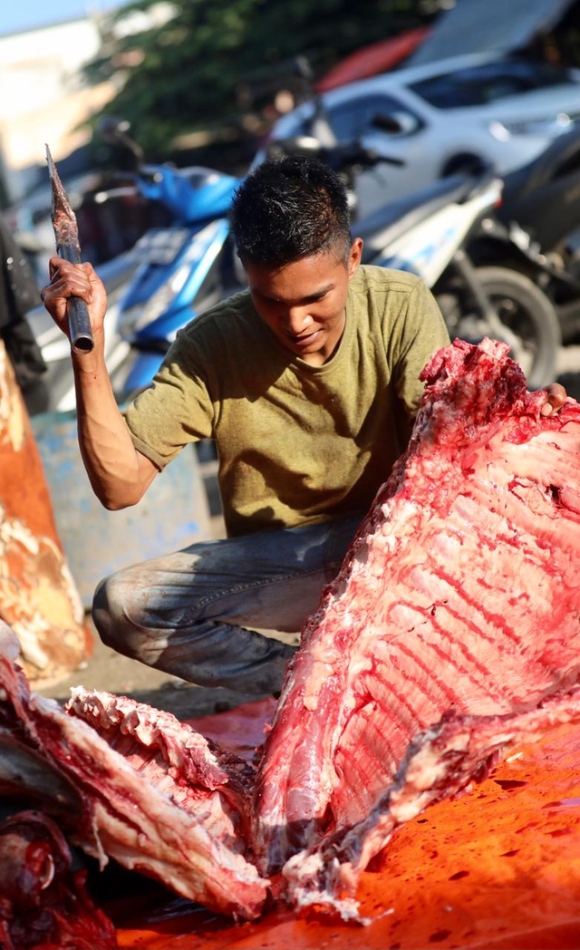 Seorang pedagang daging di Pasar Beurawe, Kota Banda Aceh, memotong tulang untuk dijual, Sabtu (10/4). Foto: Suparta/acehkini