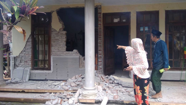 Warga menyaksikan rumah yang rusak akibat gempa di Kecamatan Turen, Kabupaten Malang, Jawa Timur, Sabtu (10/4/2021).  Foto: Syaiful Arif/ANTARA FOTO