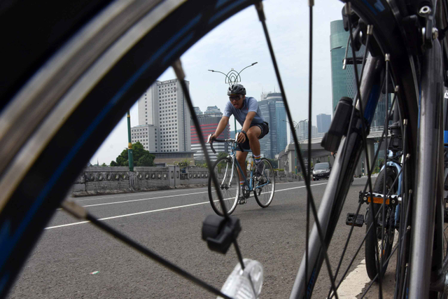 Pesepeda berolahraga di kawasan Kuningan, Jakarta, Minggu (11/4/2021).  Foto: Indrianto Eko Suwarso/ANTARA FOTO