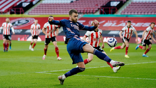 Pemain Arsenal Calum Chambers menendang bola ke arah gawang Sheffield United pada pertandingan lanjutan Premier League di Bramall Lane, Sheffield, Inggris. Foto: Tim Keeton/Pool/REUTERS