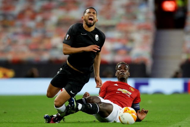 Pemain Manchester United Paul Pogba berebut bola dengan pemain Granada Yangel Herrera pada pertandingan leg kedua perempat final Liga Europa di Old Trafford, Manchester, Inggris. Foto: David Klein/REUTERS