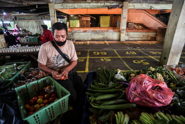Pedagang korban kebakaran di Pasar Minggu menata dagangannya di lapak sementara di Jakarta, Jumat (16/4/2021). Foto: Muhammad Adimaja/Antara Foto