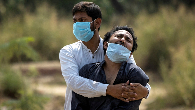 Seorang pria berduka ketika melihat jenazah ayahnya yang meninggal karena COVID, akan dikubur di pemakaman di New Delhi, India, Jumat (16/4). Foto: Danish Siddiqui/REUTERS