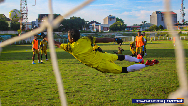 Salah satu pemain tim Sepak Bola Maluku Utara menendang bola ke arah gawang hingga mencetak gol. Saat itu, mereka sedang latihan meski sedang berpuasa pada Ramadhan, untuk kesiapan PON 2021 di Papua nanti. Foto: Faris Bobero/cermat