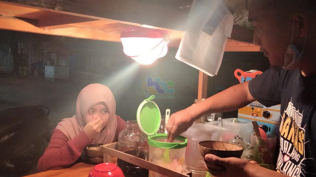 Ahcmad Sofiudin (29), penjula wedang ronde di Desa Sugihwaras, Kecamatan Sugihwaras, saat melayani pembeli. (foto: dan/beritabojonegoro)