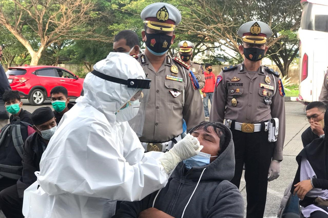 Polisi mengambil sampel swab antigen penumpang bus setiba di Terminal Batoh, Kota Banda Aceh. Foto: Dok. Ditlantas Polda Aceh