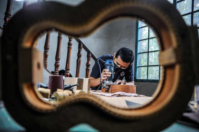 Andy Mahardika menyelesaikan pesanan ukulele di rumah produksi, Bandung, Jawa Barat. Foto: Raisan Al Farisi/ANTARA FOTO