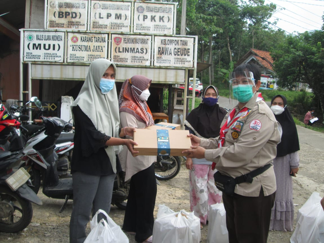 Waka Abdimas Kwarcab Bogor (kanan) sedang menyalurkan Rantang Cinta di Sukamakmur. (Kominfo Kwarcab Bogor)