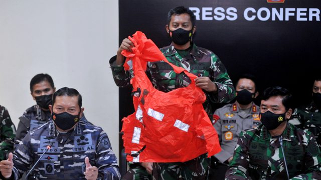 Prajurit TNI menunjukkan baju keselamatan awak kapal KRI Nanggala 402 yang ditemukan saat konferensi pers di Lanud I Gusti Ngurah Rai, Badung, Bali, Minggu (25/4). Foto: Fikri Yusuf/ANTARA FOTO