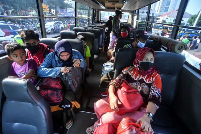 Sejumlah penumpang kendaraan travel gelap berada di dalam bis untuk diantarkan ke masing-masing terminal tujuan usai kendaraan travel gelap diamankan petugas di Lapangan Presisi Dit Lantas PMJ, Jakarta, Kamis (29/4). Foto: Muhammad Adimaja/ANTARA FOTO
