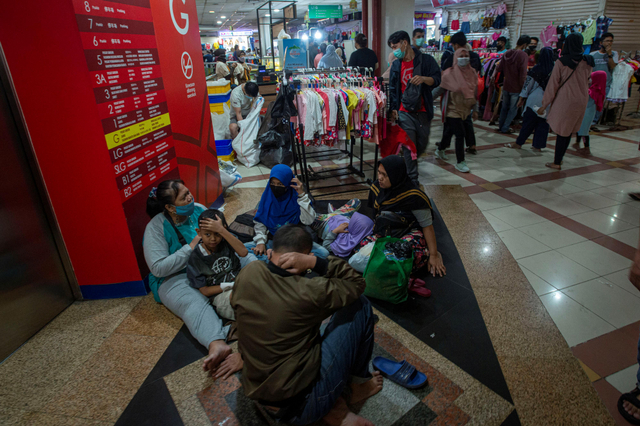 Sejumlah warga duduk beristirahat di sela kegiatan belanja di Blok B Pusat Grosir Pasar Tanah Abang, Jakarta Pusat, Minggu (2/5). Foto: Aditya Pradana Putra/Antara Foto