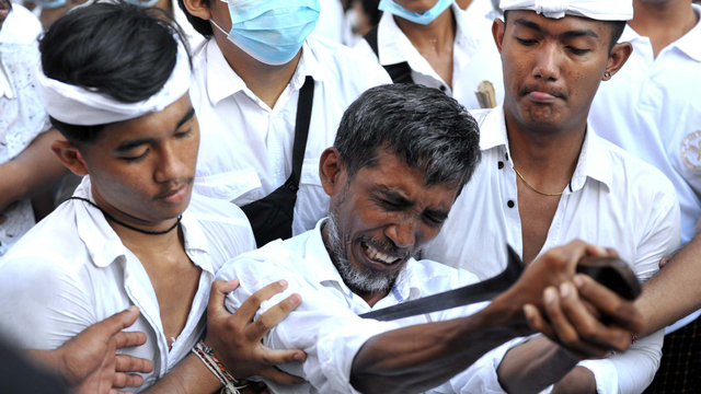 Seorang umat Hindu yang kesurupan menusukkan keris ke tubuhnya saat Tradisi Ngerebong di Denpasar, Bali, Minggu (2/5/2021). Foto: Fikri Yusuf/ANTARA FOTO