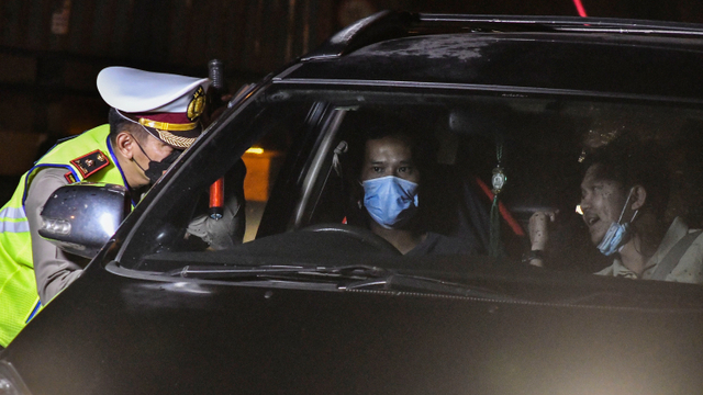 Petugas Kepolisian (kiri) memeriksa dokumen pengendara yang melintas di check point penyekatan arus mudik di Tol Cikarang Barat, Kabupaten Bekasi, Jawa Barat, Kamis (6/5).  Foto: Fakhri Hermansyah/ANTARA FOTO